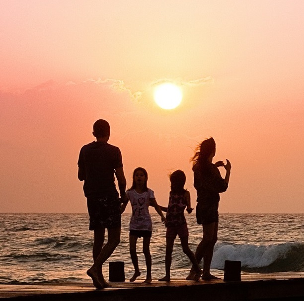 a photo of a young family on a sunrise beach.